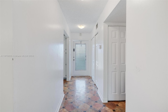 hallway featuring a textured ceiling