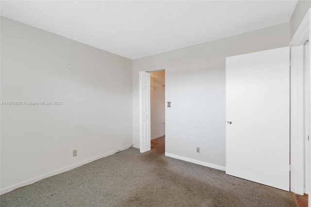 empty room featuring dark carpet