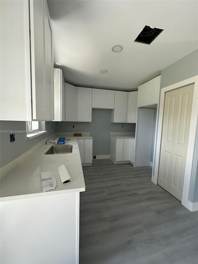 kitchen featuring white cabinetry, light hardwood / wood-style floors, light stone countertops, and sink