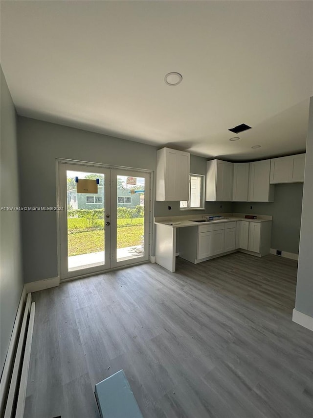 kitchen featuring french doors, white cabinetry, sink, and light wood-type flooring