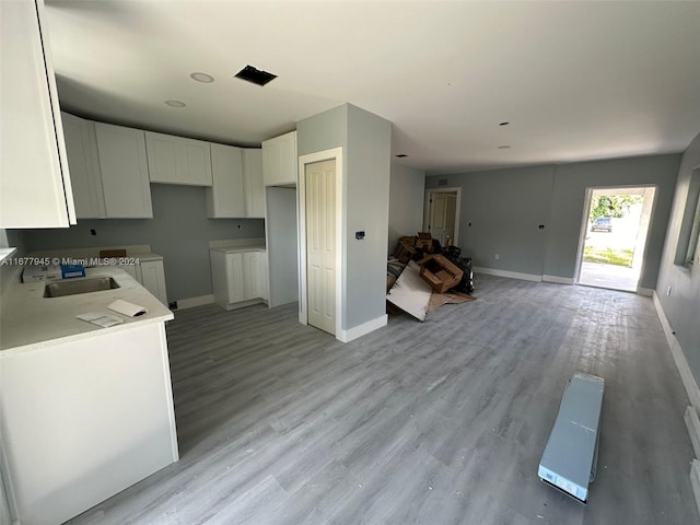 kitchen featuring white cabinetry, light hardwood / wood-style floors, and sink