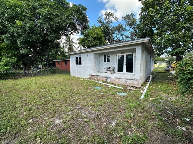 rear view of property featuring a lawn