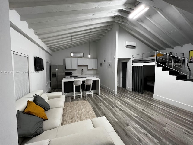 living room featuring a wall unit AC, hardwood / wood-style floors, high vaulted ceiling, beamed ceiling, and sink