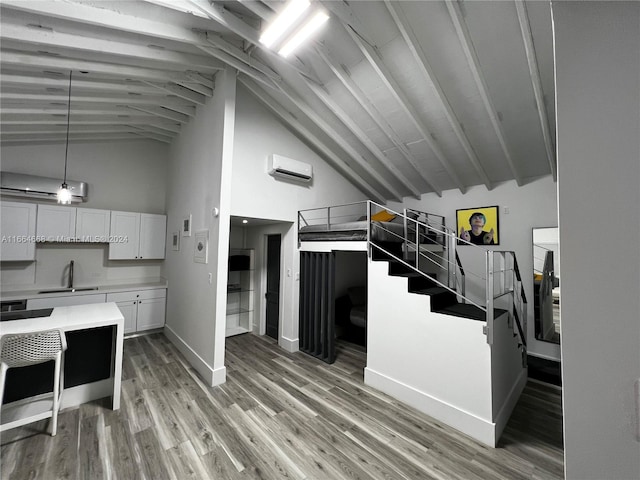 kitchen featuring a wall unit AC, light hardwood / wood-style flooring, white cabinetry, and sink