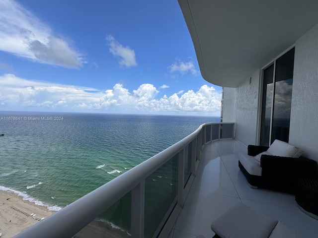 balcony featuring a water view and a view of the beach