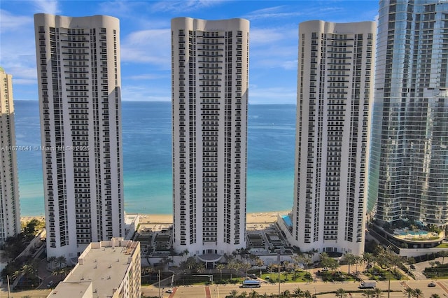 birds eye view of property featuring a water view, a view of the beach, and a city view