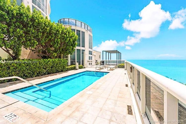 view of pool featuring a patio area and a water view