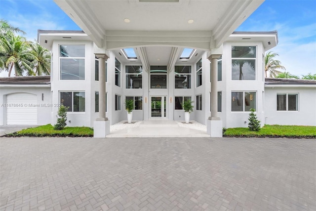 unfurnished sunroom featuring beam ceiling and ornate columns