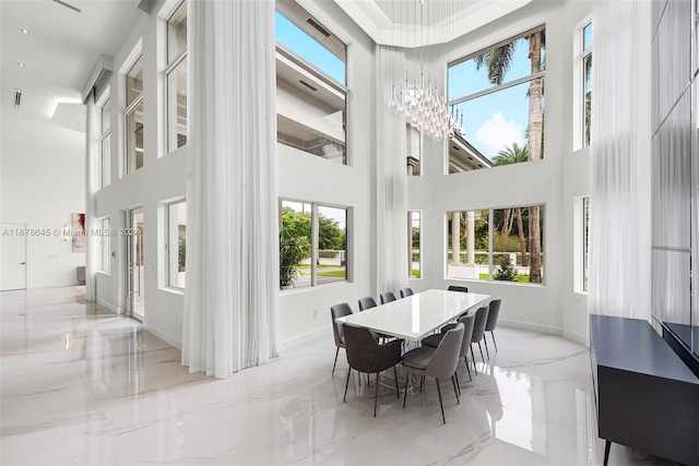 dining room with a towering ceiling and plenty of natural light