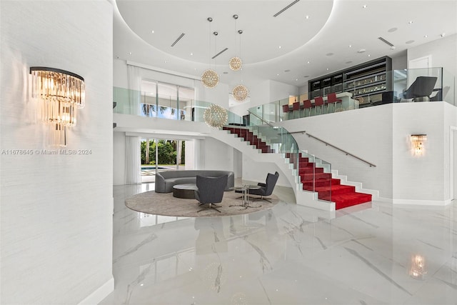 stairway with an inviting chandelier and a high ceiling