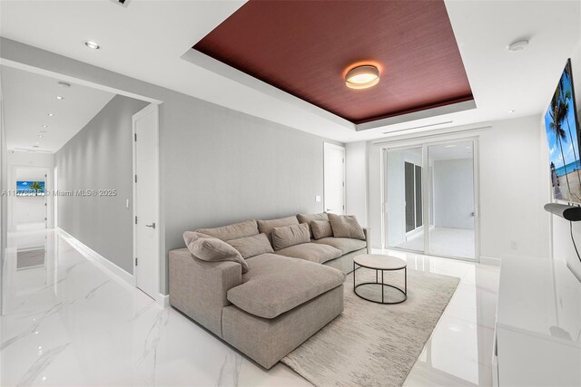 living room featuring electric panel and a tray ceiling