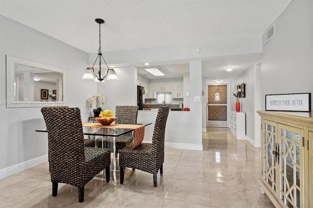 dining area with a notable chandelier and a textured ceiling