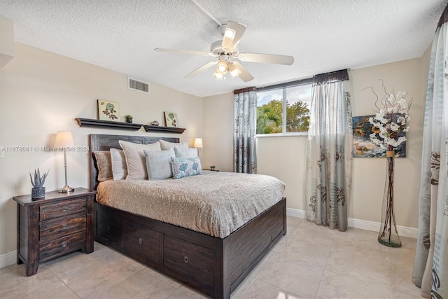 bedroom with a textured ceiling and ceiling fan