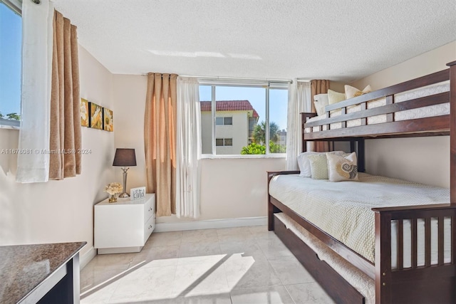 tiled bedroom featuring a textured ceiling