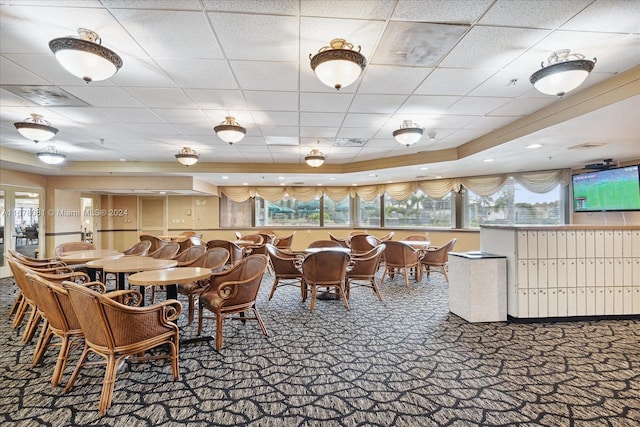 dining room featuring carpet floors and a drop ceiling