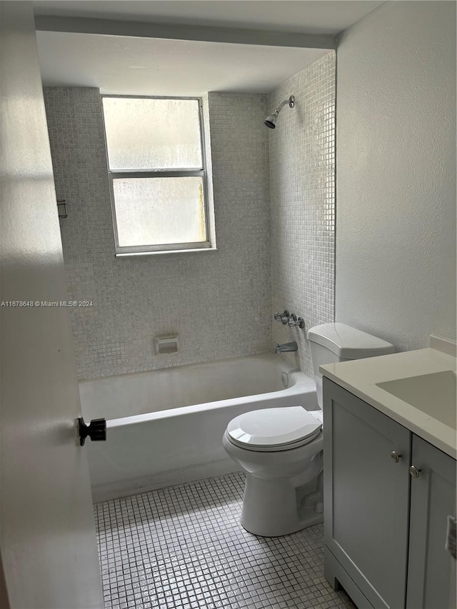 full bathroom with vanity, toilet, tiled shower / bath combo, and tile patterned flooring