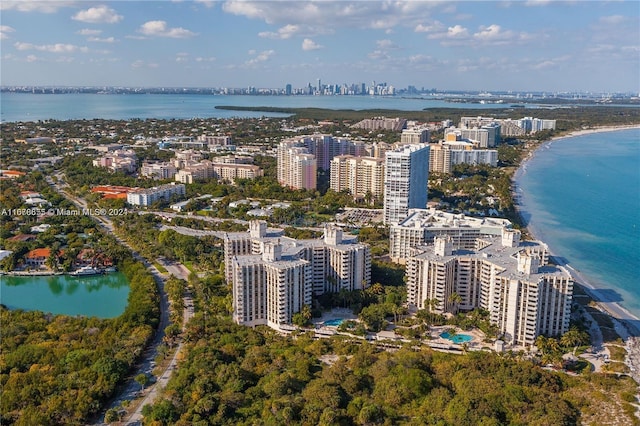 birds eye view of property with a water view and a beach view