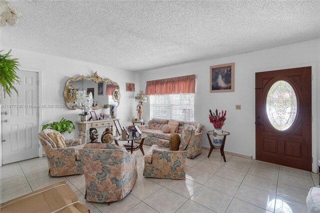 living room featuring a textured ceiling and light tile patterned floors