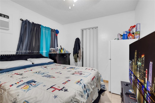 bedroom with a textured ceiling and light tile patterned floors