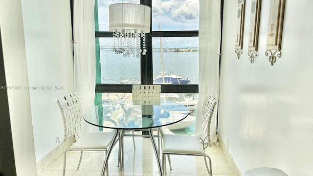 dining room featuring a water view and light tile patterned floors