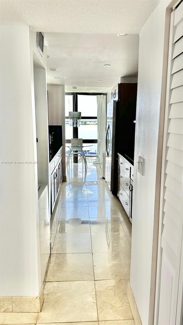 hallway featuring expansive windows and a textured ceiling