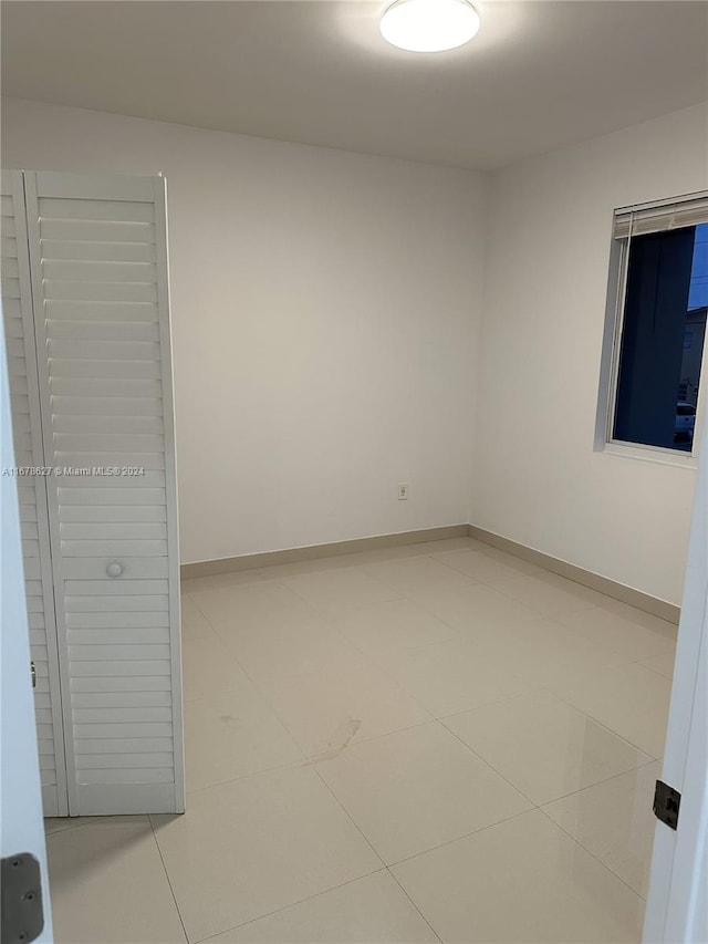 unfurnished room featuring tile patterned flooring