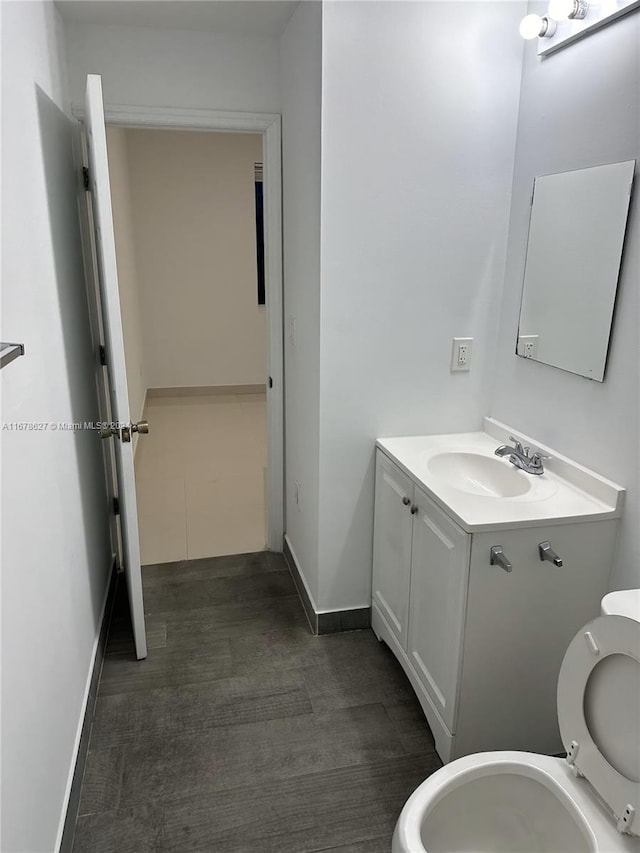 bathroom with vanity, toilet, and hardwood / wood-style floors