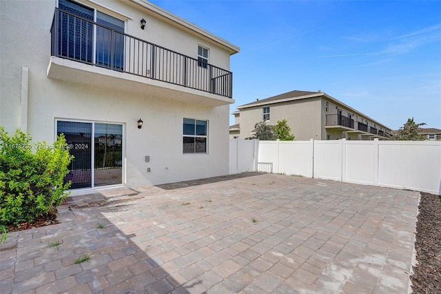 rear view of house featuring a patio and a balcony