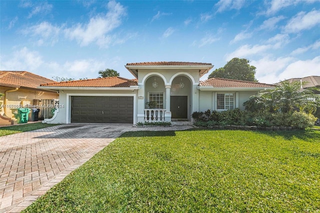 mediterranean / spanish-style home featuring a front lawn and a garage