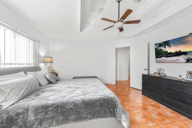 tiled bedroom with crown molding, a tray ceiling, and ceiling fan