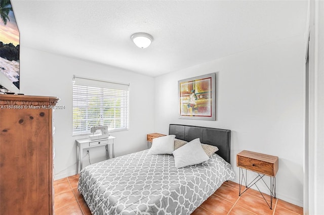 bedroom with a textured ceiling and light tile patterned floors