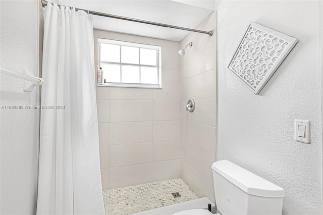 bathroom featuring a shower with shower curtain and toilet