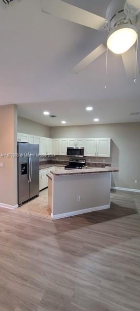 kitchen with white cabinetry, ceiling fan, stainless steel appliances, and light wood-type flooring