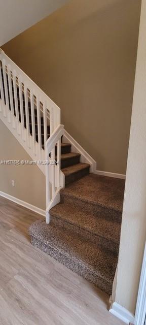 stairway with hardwood / wood-style floors