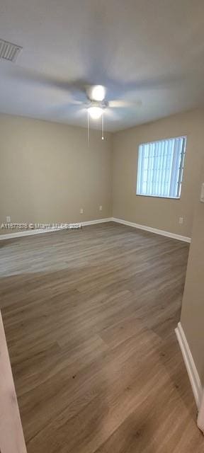 unfurnished room with dark hardwood / wood-style floors and ceiling fan