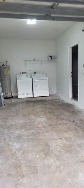 garage with independent washer and dryer and electric water heater