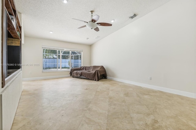 unfurnished room with lofted ceiling, ceiling fan, and a textured ceiling