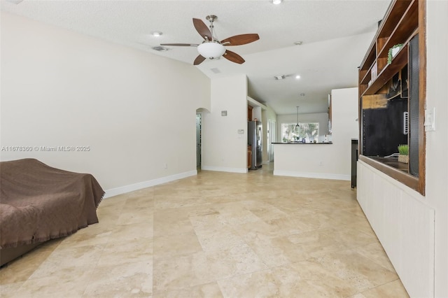 living room featuring a textured ceiling, ceiling fan, and lofted ceiling