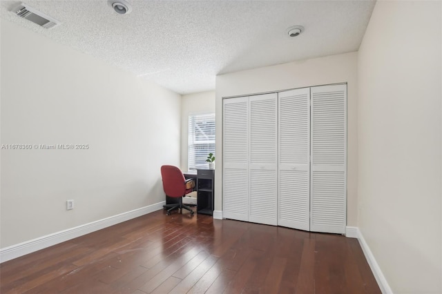 unfurnished office featuring a textured ceiling and dark hardwood / wood-style flooring