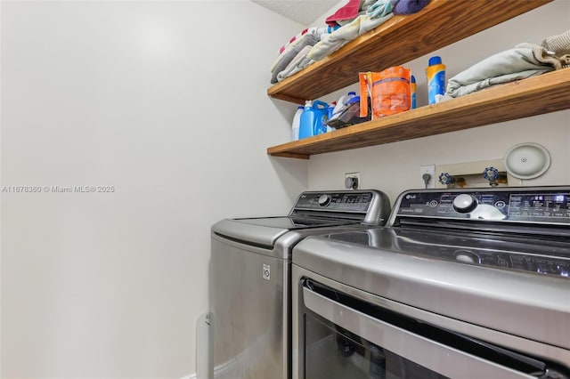 clothes washing area with a textured ceiling and separate washer and dryer