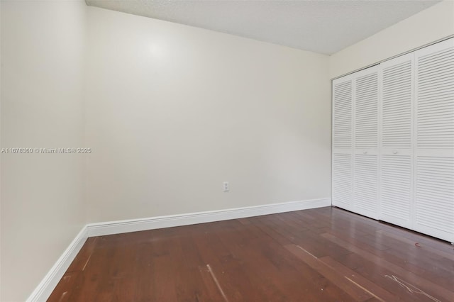 unfurnished bedroom with a closet, wood-type flooring, and a textured ceiling