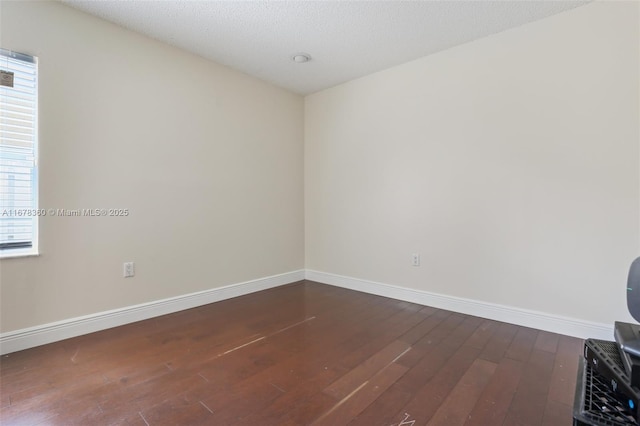 empty room featuring wood-type flooring and a textured ceiling