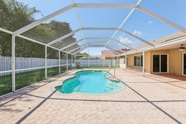 view of swimming pool with glass enclosure and a patio