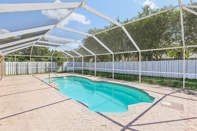 view of pool with glass enclosure and a patio area