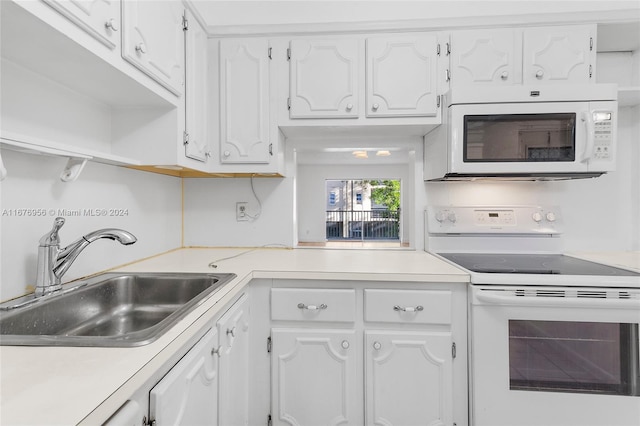 kitchen with white appliances, sink, and white cabinets