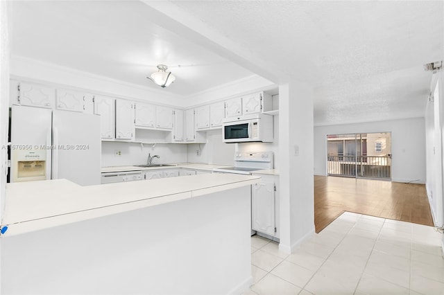 kitchen with light hardwood / wood-style flooring, sink, white cabinets, a textured ceiling, and white appliances