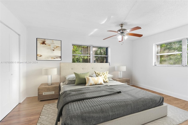 bedroom featuring a textured ceiling, hardwood / wood-style flooring, and ceiling fan