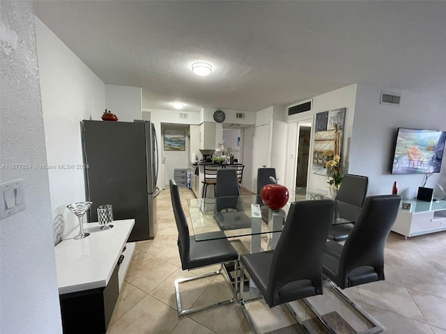 dining room with a textured ceiling and light tile patterned flooring