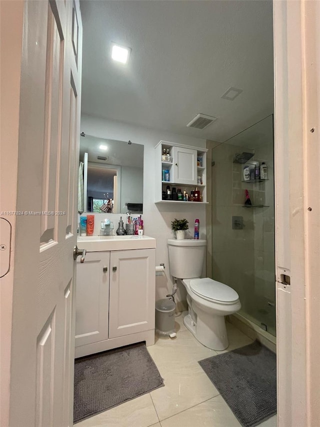 bathroom with vanity, a shower with shower door, toilet, and tile patterned flooring