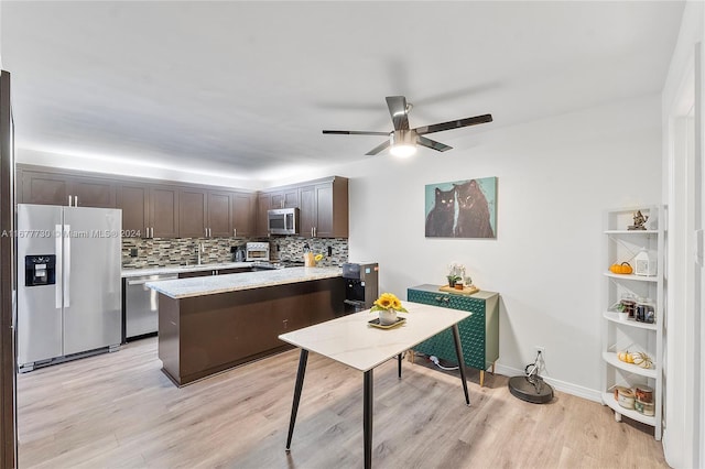 kitchen with decorative backsplash, dark brown cabinets, ceiling fan, appliances with stainless steel finishes, and light wood-type flooring